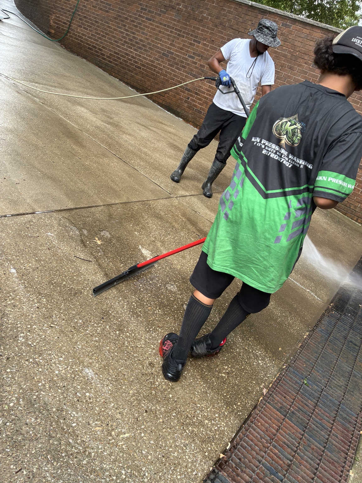 KIKN team pressure washing a concrete walkway